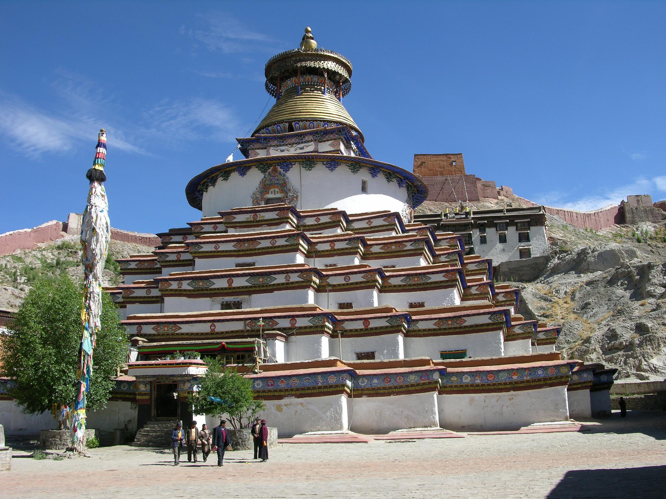 Tibet 06 07 Gyantse Kumbum Outside Commissioned by a Gyantse prince in 1270, the Kumbum chorten was built in the style of a 108-sided mandala by craftsman from the Kathmandu Valley, and houses many excellent unique frescoes of Newari influence, a painting style originating in Nepal's Kathmandu Valley. It rises in eight stages to over 52m and has lots of images (Kumbum means '100,000 images') and 70 chapels. It is topped in typical Nepalese Buddhist style with the all-seeing eyes, the spire, umbrella and the pinnacle. The first five floors are four-sided, while the upper floors are circular, forming a huge three-dimensional mandala.